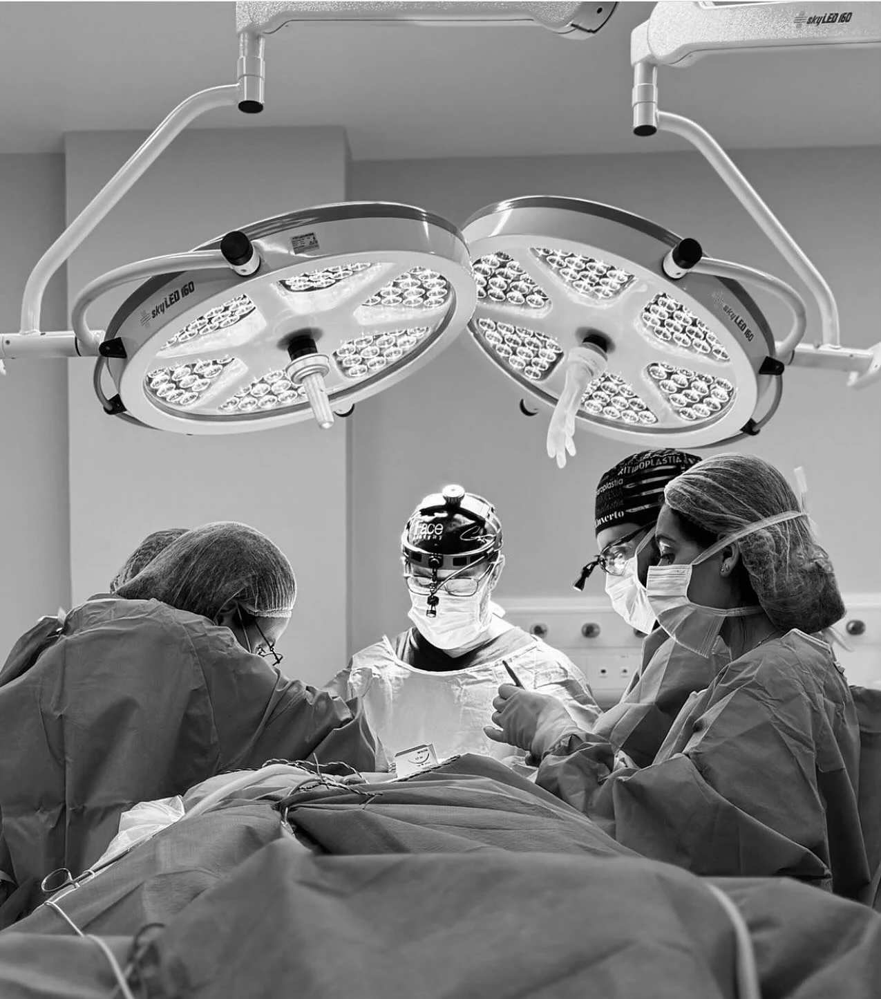 A team gathered in an operating theatre, photograph published by Clinique World